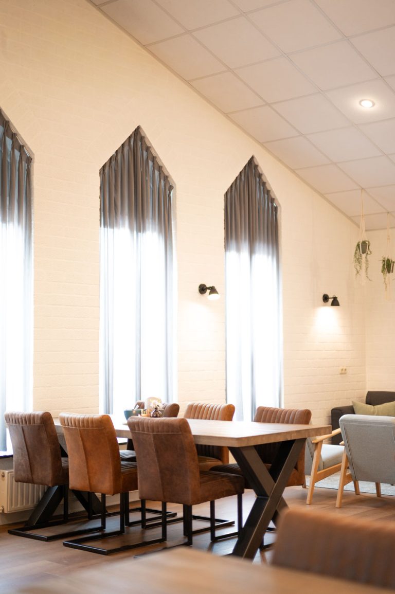 Huiskamer van het uitvaartcentrum met lange tafels